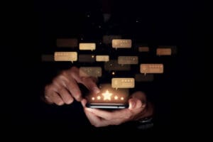 Consumer reviews concept, Hand of man using smartphone with five star for evaluate product and service.